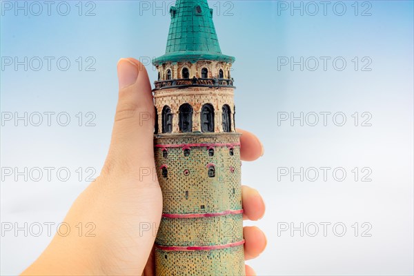 Hand holding a model of the Galata Tower in Istanbul