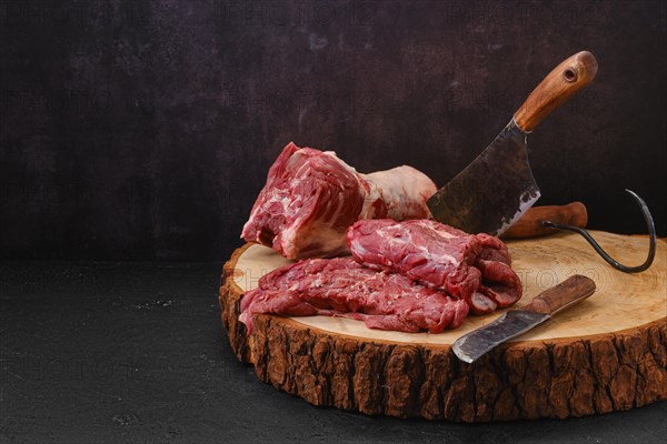 Pieces of fresh lamb neck on cutting stump in slaughterhouse