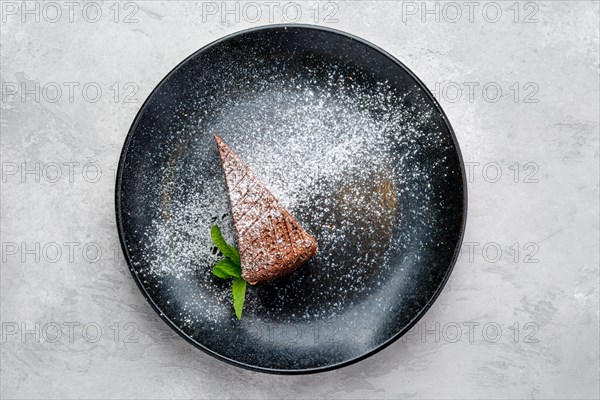 Top view of triangular piece of chocolate cake on a plate