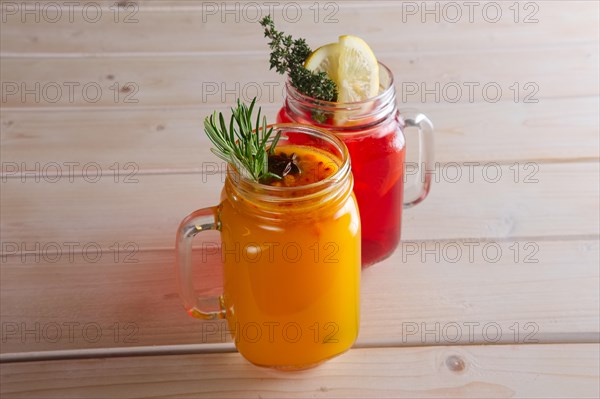 Two cups of cranberry tea and sea buckthorn tea with citrus