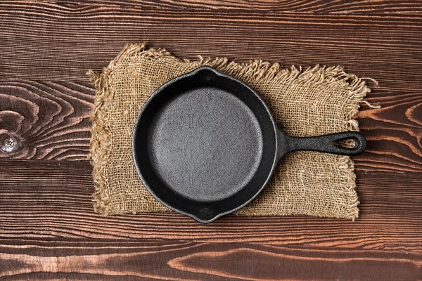 Empty mini cast-iron skillets on wooden table