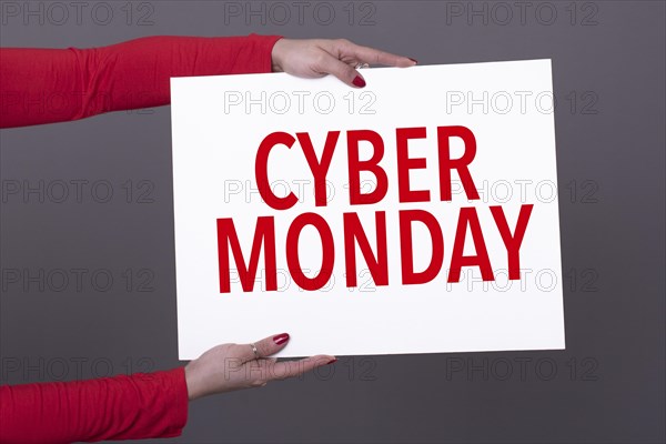 Female hands holding a cyber monday poster. Studio shot