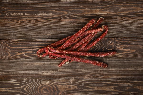 Overhead view of air dried deer and pork sausage on wooden background
