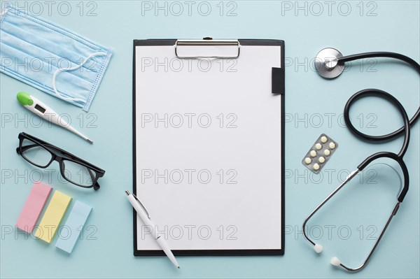 Overhead view healthcare accessories near clipboard with plank paper spectacles background