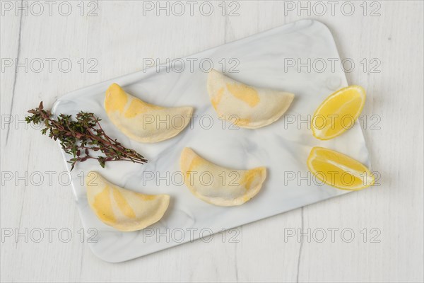 Top view of semifinished frozen salmon dumplings on serving board