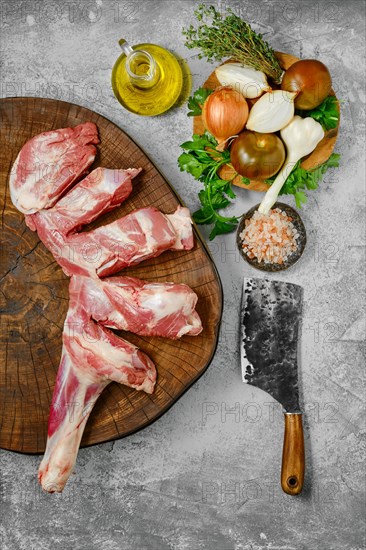 Raw lamb shoulder half cut on wooden slab