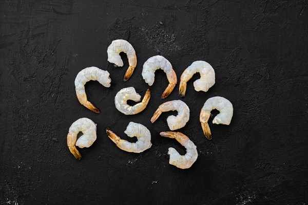 Peeled fresh raw white prawns on wooden background