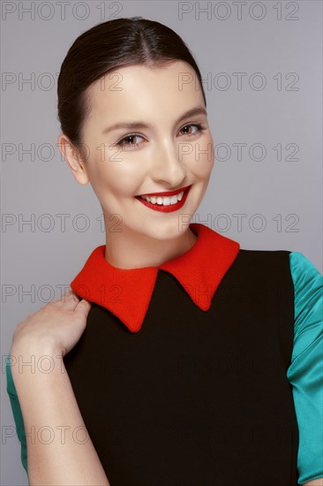 Pretty young fashion model with tan skin and red mat lips. Beauty shoot