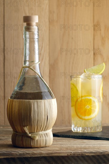 Bottle of homemade Vodka and glass witn orange juice cocktail