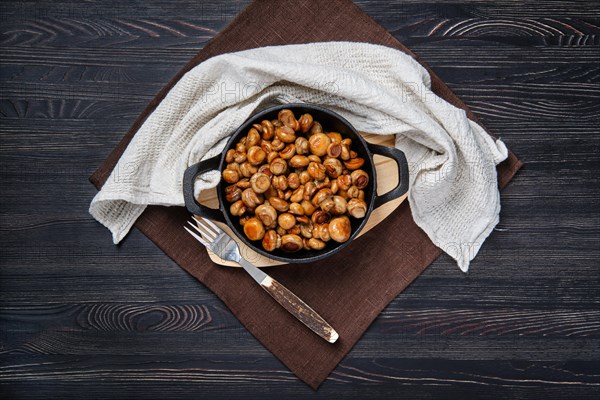 Overhead view of cast iron skillet with fried champignon with spice