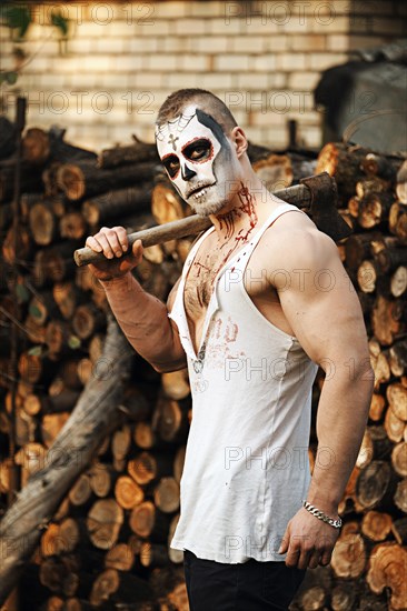 Male daemon with axe near firewood placing. Face painting art