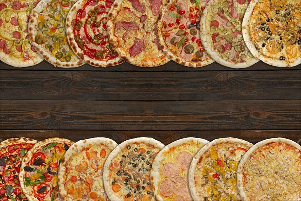 Horizontal collage of different baked pizzas on dark wooden table. Top view