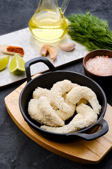 Prepared for frying uncooked shrimps in cheese breading with spice