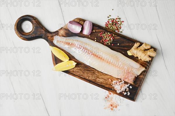 Top view of freshly frozen zander fillet on wooden cutting board