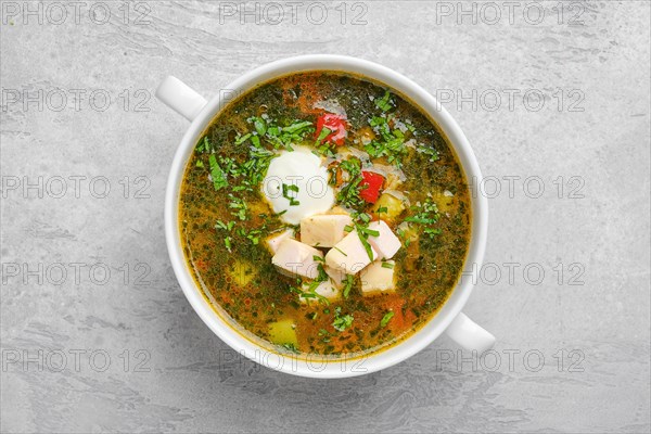 Top view of vegetable soup with chicken fillet and sour cream