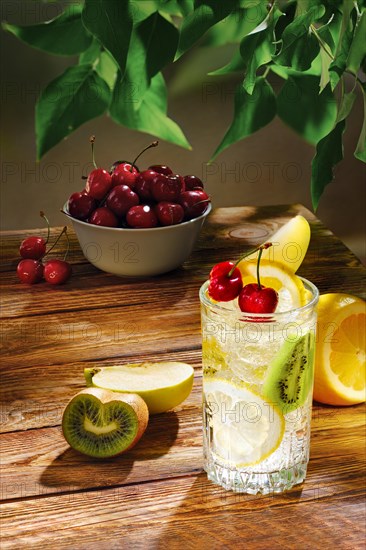 Cold apple and kiwi lemonade on table in the garden in morning sunlight