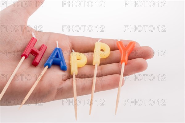 Color candles on sticks write the word happy