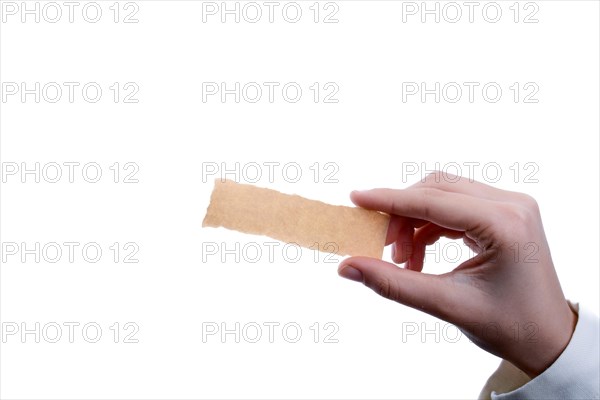 Hand holding a piece of blank torn notepaper