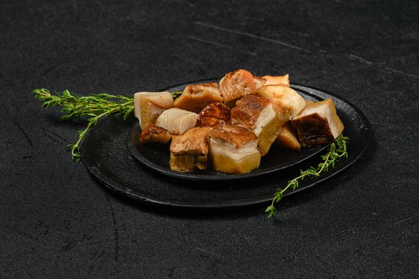 Frozen fresh boletus cut on pieces on black stone plate