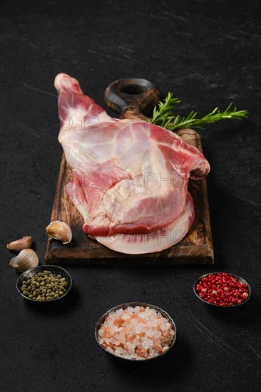 Raw fresh lamb shoulder on wooden cutting board