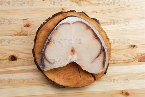 Top view of frozen blue shark steak on wooden table