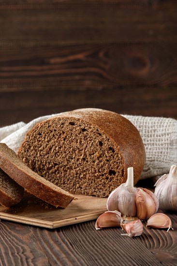 Brown garlic bread on cutting board on the table