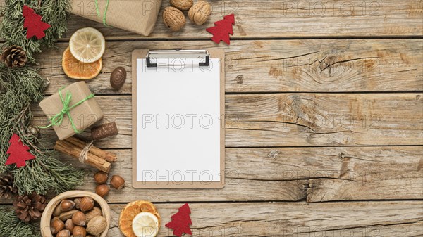 Flat lay festive christmas table arrangement with empty clipboard copy space