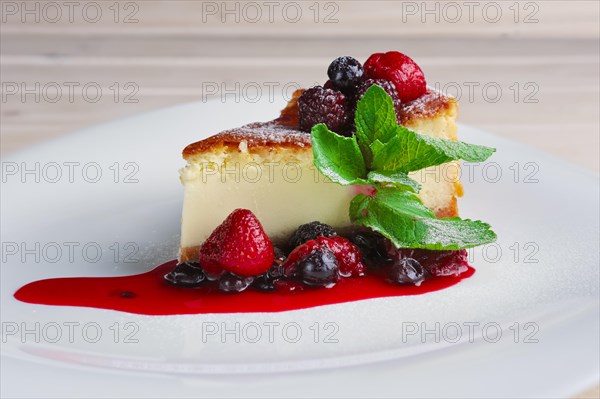 Cheesecake with berries sauce and green mint leaf