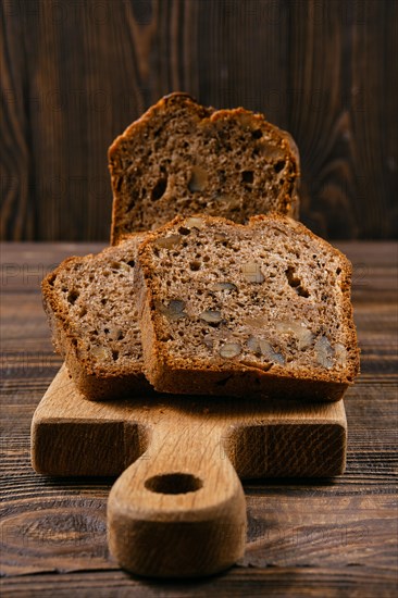 Closeup view of biscuit cake with walnut on wooden board