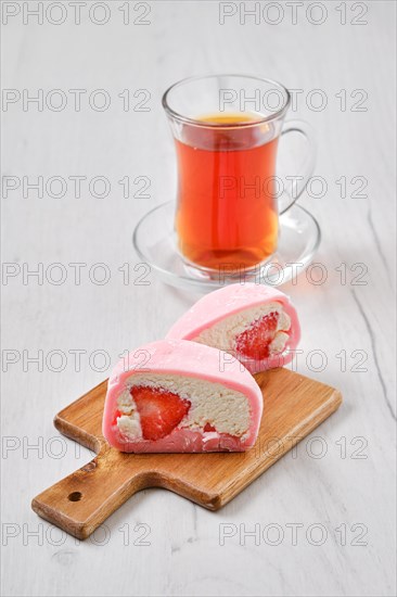 Sweet dessert mochi with strawberry cut on half with fruit tea