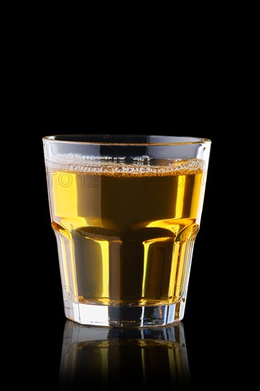Fresh apple juice in rocks glass isolated on black background