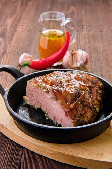 Closeup view of oven-baked meat with braised cabbage and zucchini and hot spicy sauce