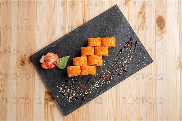 Set of rolls with wasabi and pickled ginger on stone serving board