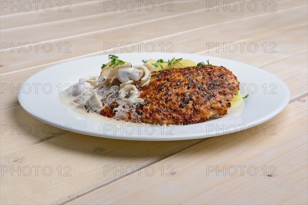 Fried chicken fillet in rosemary breading served with boiled potato and mushroom creamy sauce