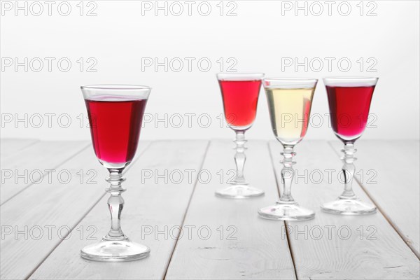 Vodka infused with berries on wooden background