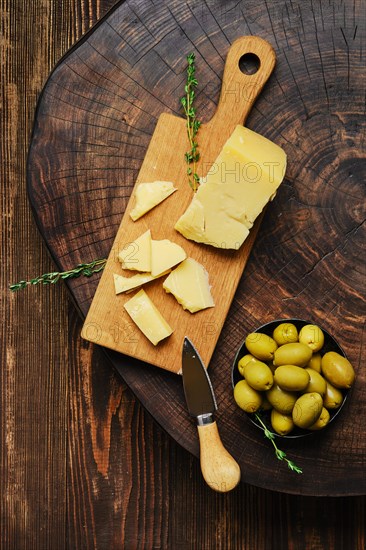 Overhead view of triangular piece of parmesan cheese on wooden cutting board