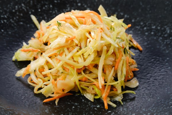 Pickled slices of cabbage and carrot on a plate