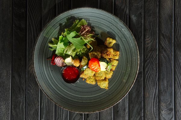 Top view of fried falafel with grilled vegetables on wooden skewer