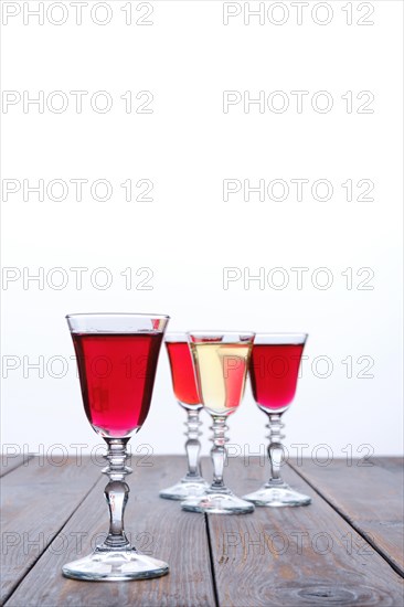 Vodka infused with berries on wooden background