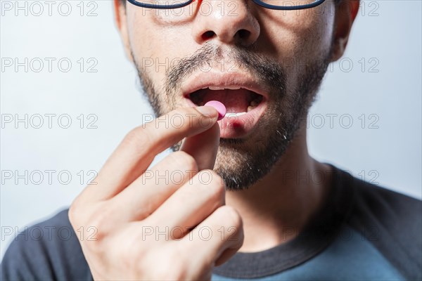 Person taking a pill isolated