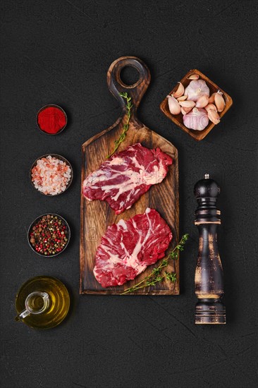Overhead view of black table with raw fresh beef top blade steak