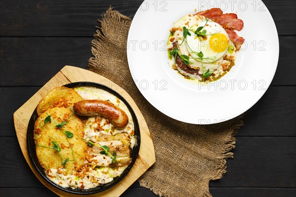 Top view of potato fritters with with fried german sausage and pork belly slices