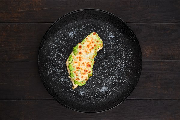 Top view of fried fish fillet with green salsa sauce on a plate