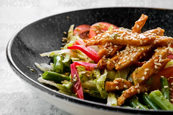Closeup view of salad with chicken and teriyaki sauce