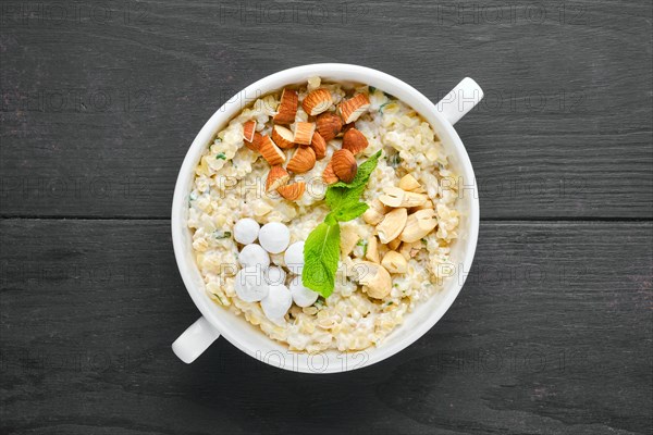 Overhead view of bulgur porridge with almond nuts and hazelnuts and cranberries in sugar pouder breading