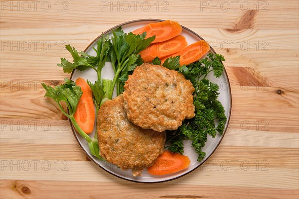 Fried beef cutlet in breading with fresh carrot