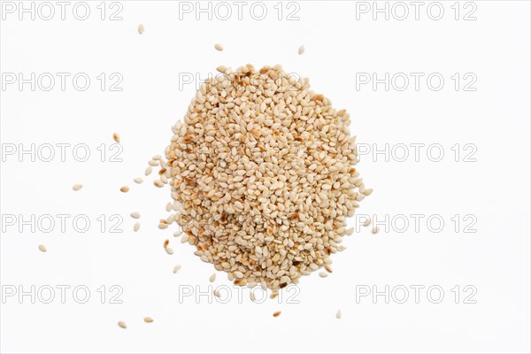 Top view of sesame seeds scattered on white paper