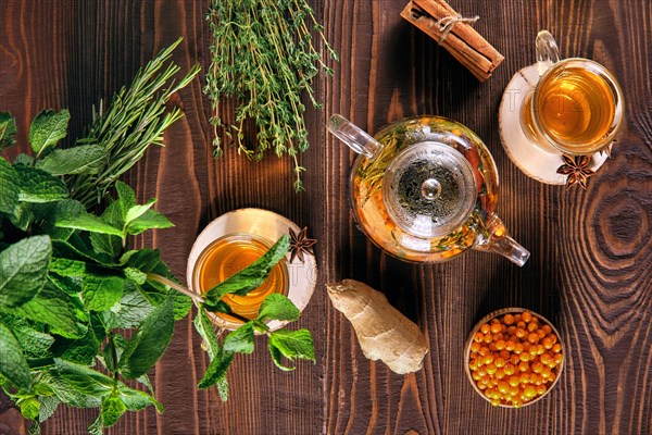 Top view of sea-buckthorn drink with thyme and cinnamon on wooden table