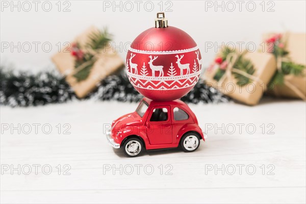 Toy car with red christmas ball near present boxes. Resolution and high quality beautiful photo