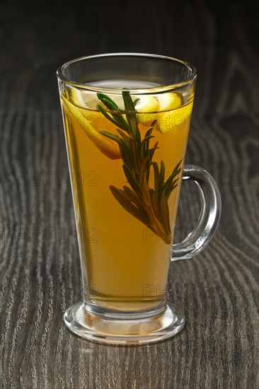 Glass of hot fruit tea on wooden table